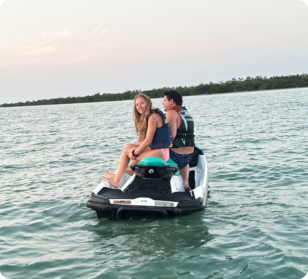Two people on a jet ski in the water.