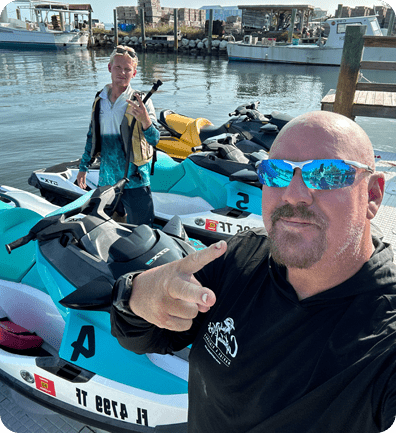 A man and woman in blue jet skis on the water.