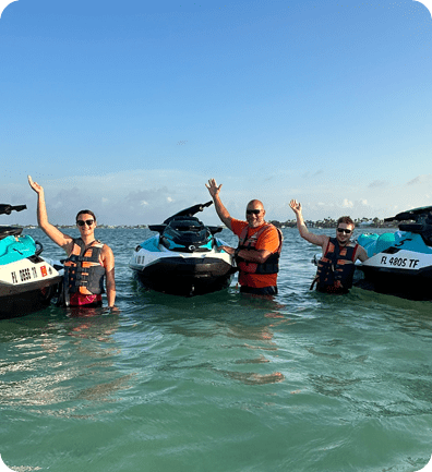 A group of people in the water with jet skis.