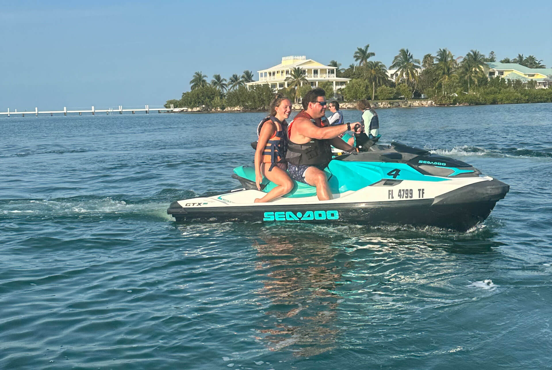 A man and two women on a jet ski.